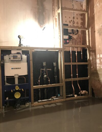Bathroom first-fix with Geberit frame and copper pipework on a studded wall