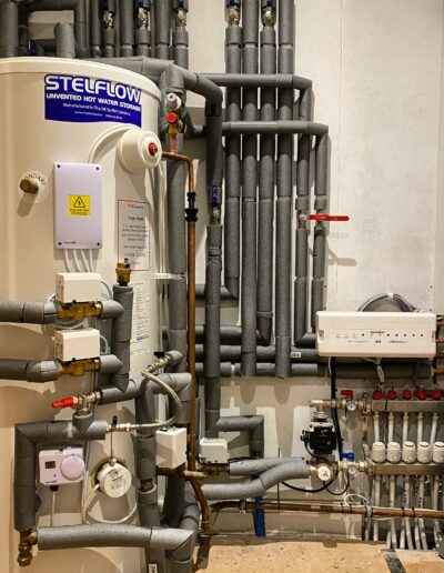 Stelflow unvented hot water cylinder with Heatmiser underfloor heating manifold and insulated pipework